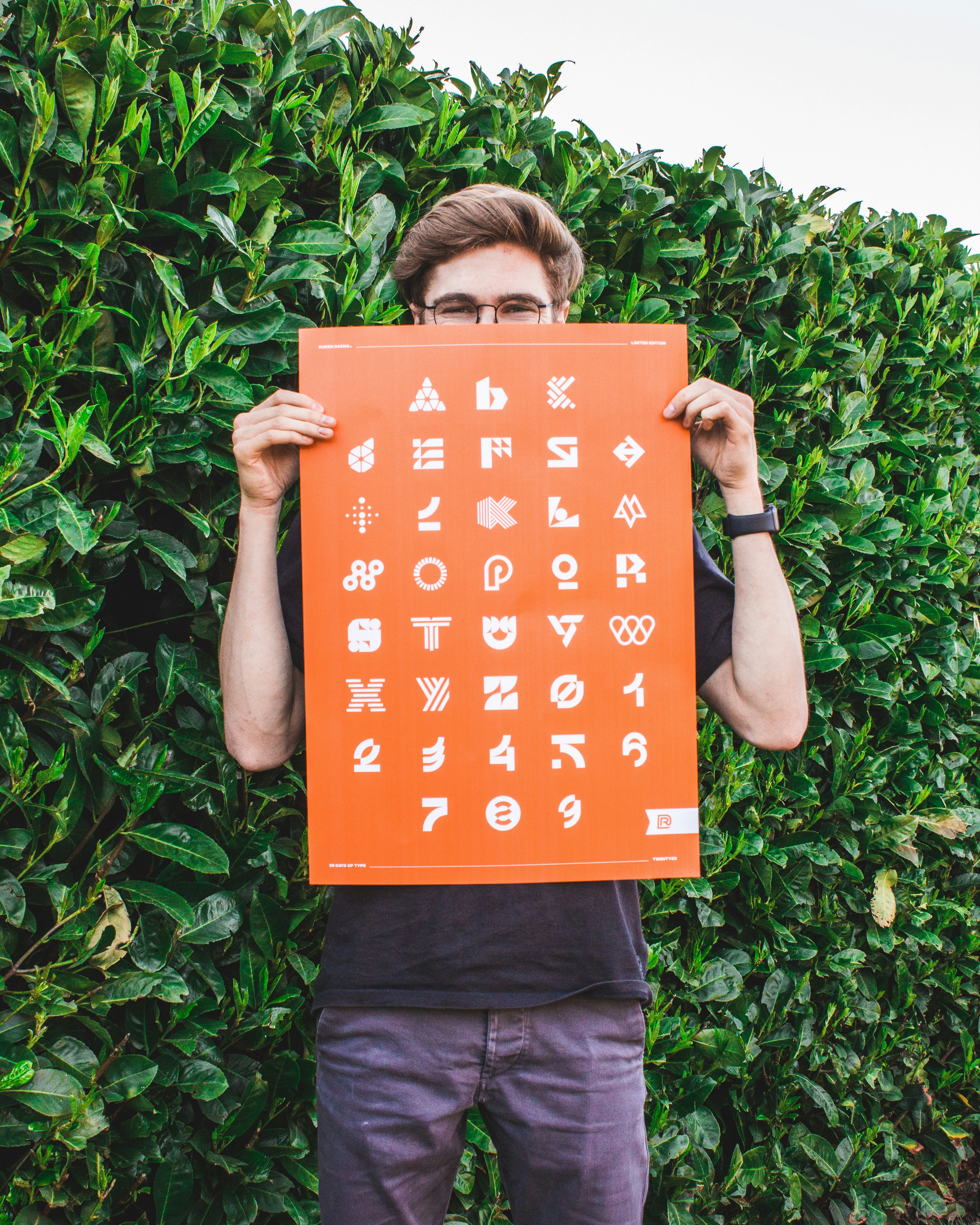 garçon en t-shirt noir tenant un livre orange