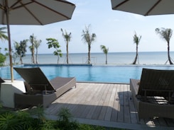 Close-up of elegant wooden pool decking with comfortable lounge chairs.