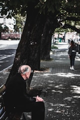 woman in black jacket standing beside tree during daytime