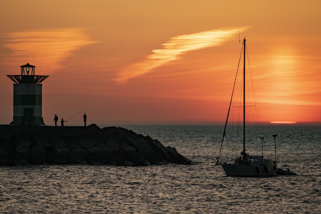 silhouette of boat on sea during sunset