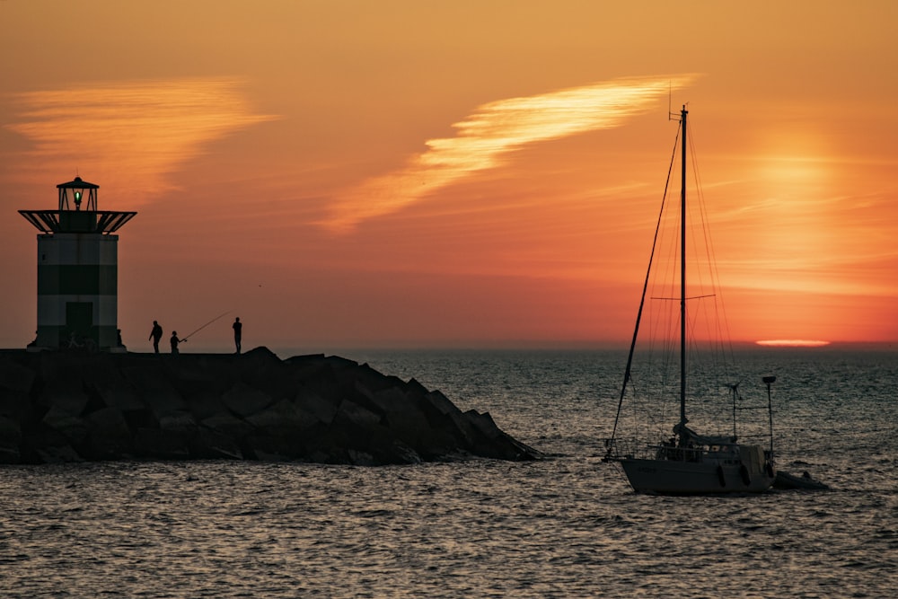 silhouette of boat on sea during sunset