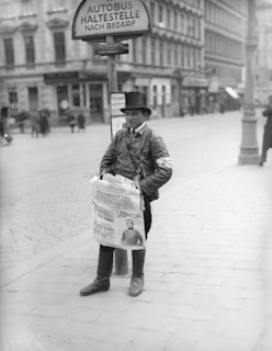 A street vendor selling newspapers with headlines about the stock market.
