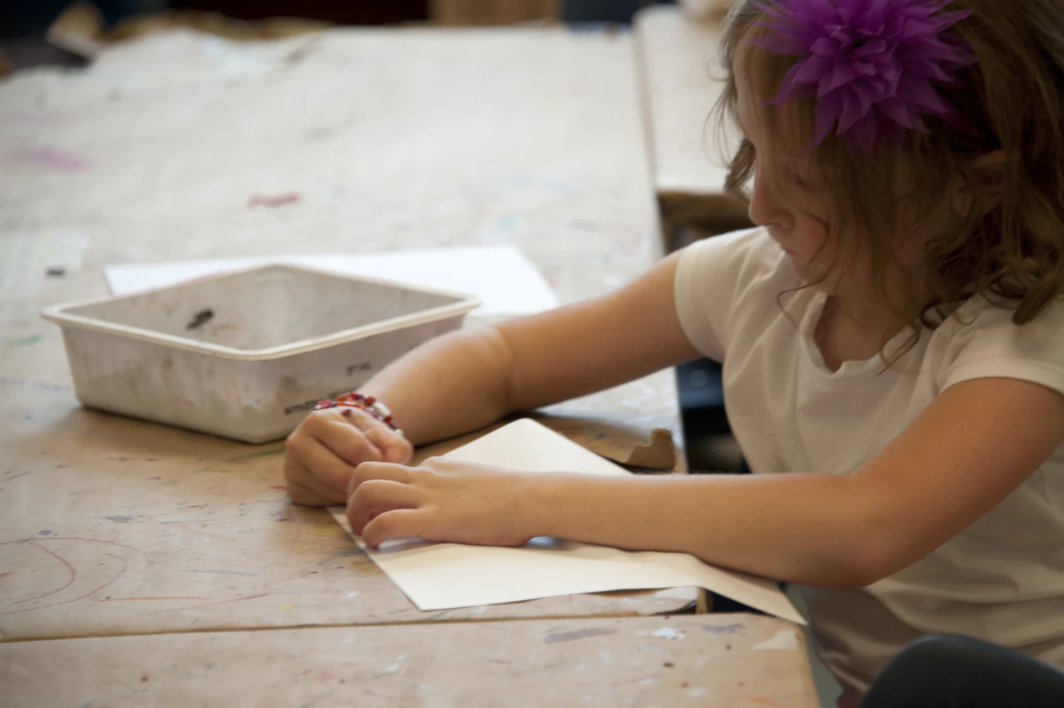 Child's hands cutting paper with kids' safety scissors