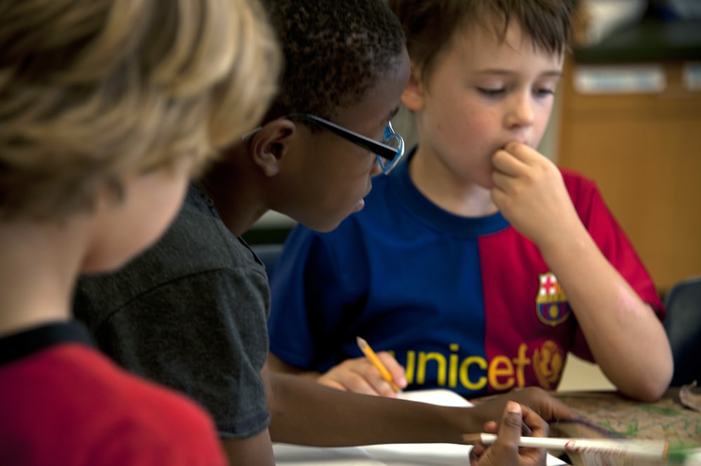 boy in blue crew neck t-shirt holding chopsticks