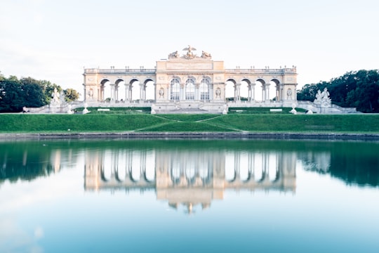 white concrete building near body of water during daytime in Schönbrunn Garden Austria