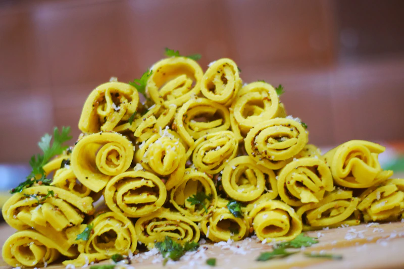 Delicate rolled khandvi topped with mustard seeds and coconut