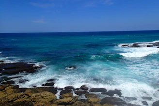 Waves crashing against the rocky Atlantic coastline, with surfers catching the perfect wave under a vibrant sky.