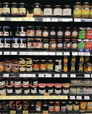 A consultant discussing go-to-market plans with a client over a table filled with jam jars and beverage samples.