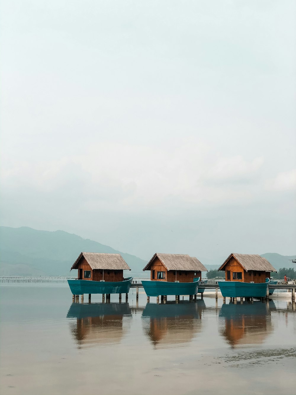 houses on body of water under white sky during daytime