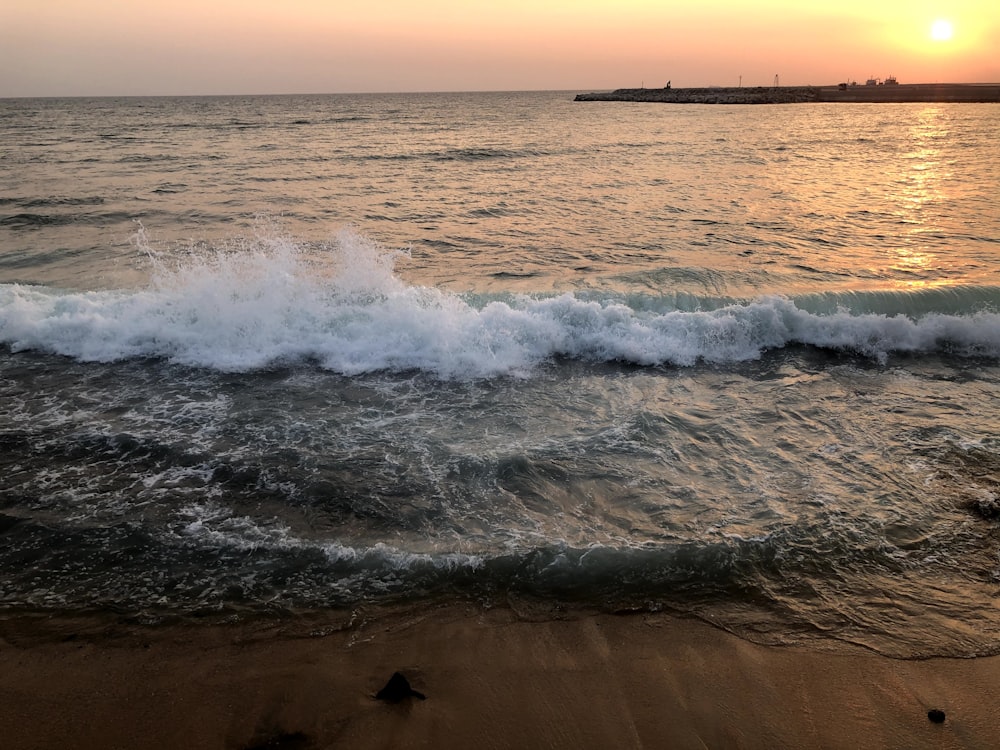 sea waves crashing on shore during daytime