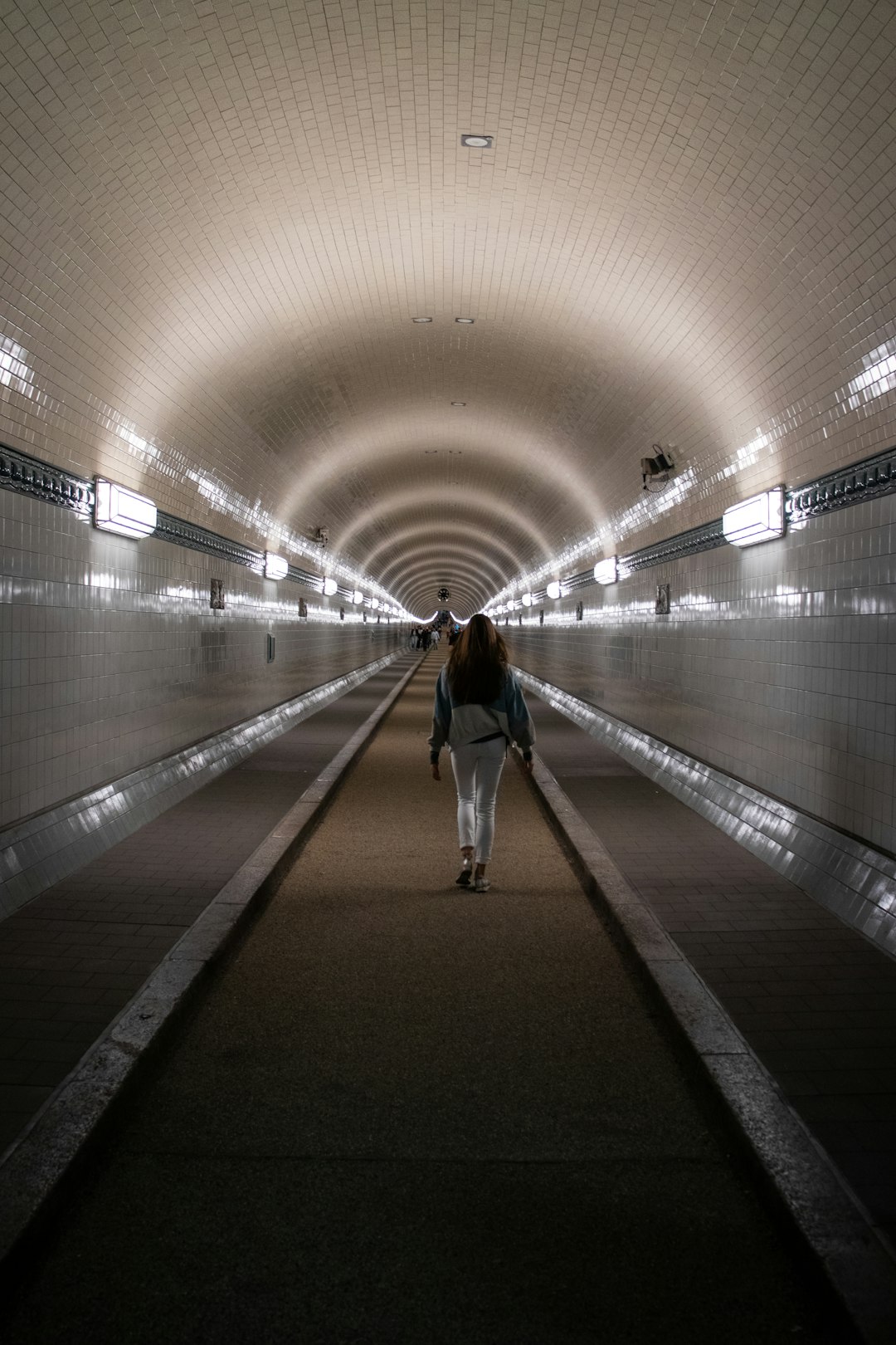 woman in white shirt walking on hallway