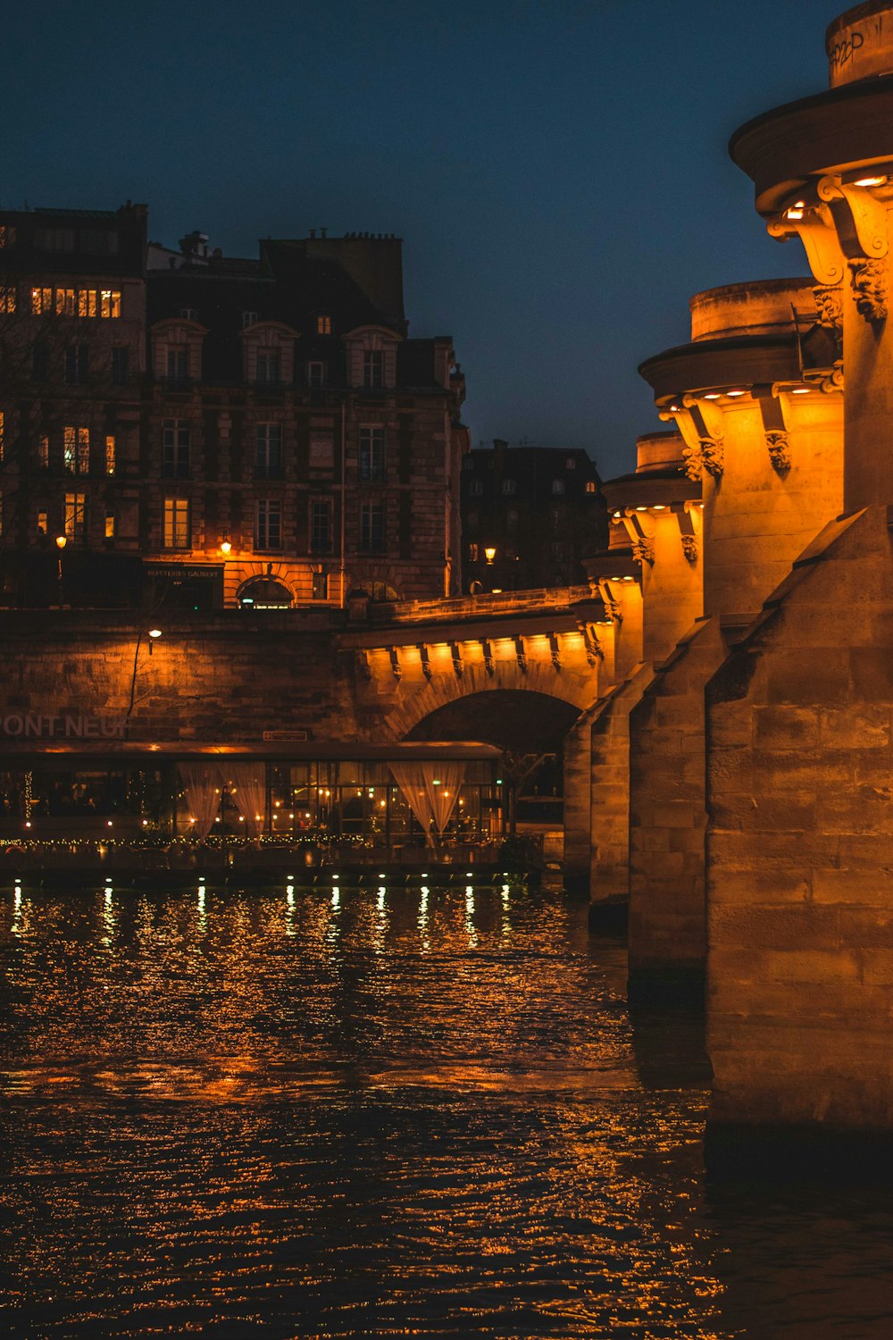 夜間の水上に架かる茶色のコンクリート橋