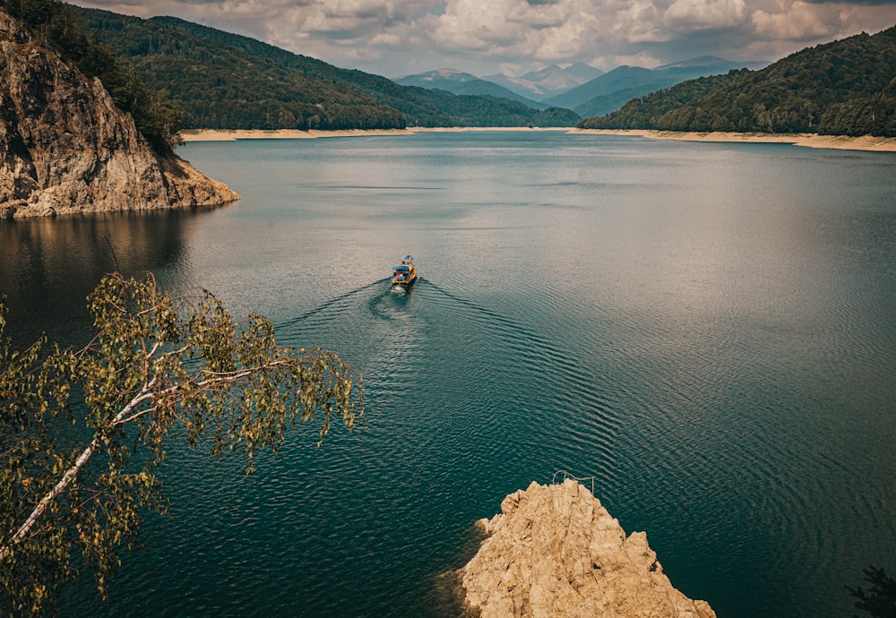 person in blue jacket and blue jeans riding on blue kayak on lake during daytime