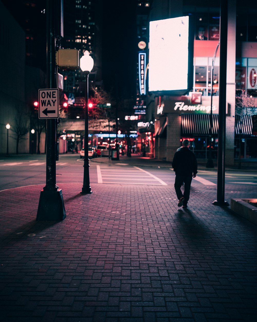 person walking on sidewalk during night time