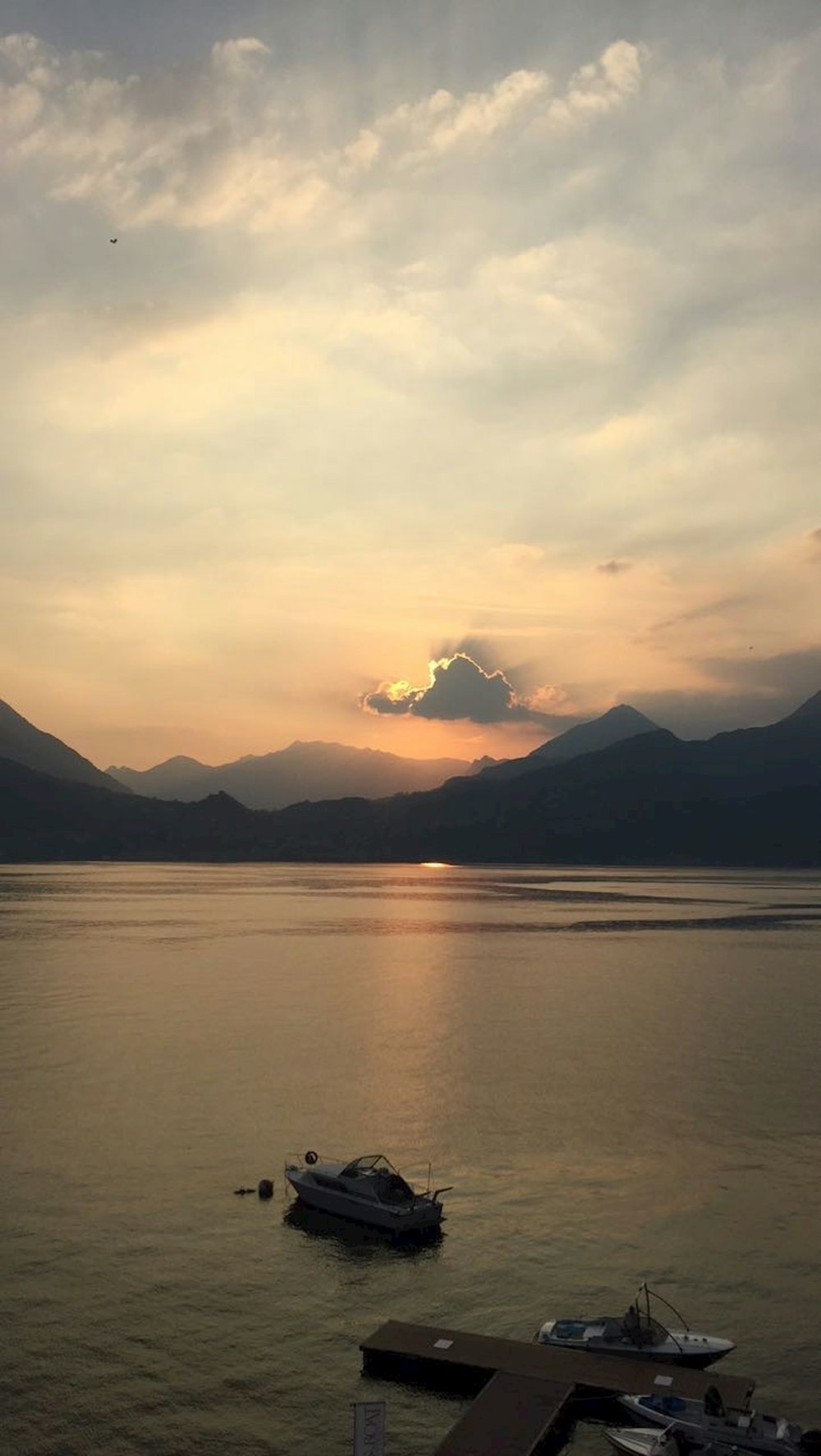 silhouette of mountains near body of water during sunset