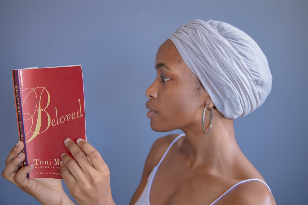 woman in white tank top holding red card