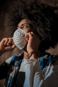 Close-up of hands applying nourishing hair mask to curly hair.