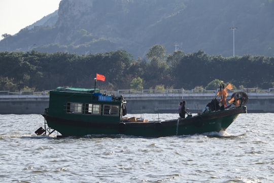 man and woman riding on boat on body of water during daytime in Zhuhai China