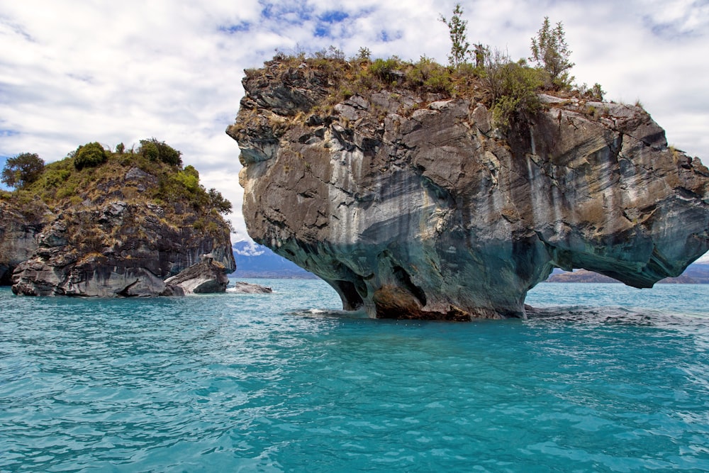 brown rock formation on body of water during daytime