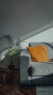 orange throw pillow on gray couch