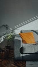 orange throw pillow on gray couch