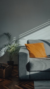 orange throw pillow on gray couch