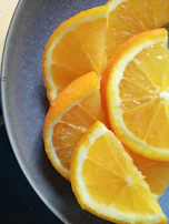 Juicy orange slices arranged artfully on a bright white plate.