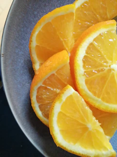 Juicy orange slices arranged artfully on a bright white plate.