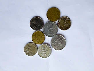 gold round coins on white textile