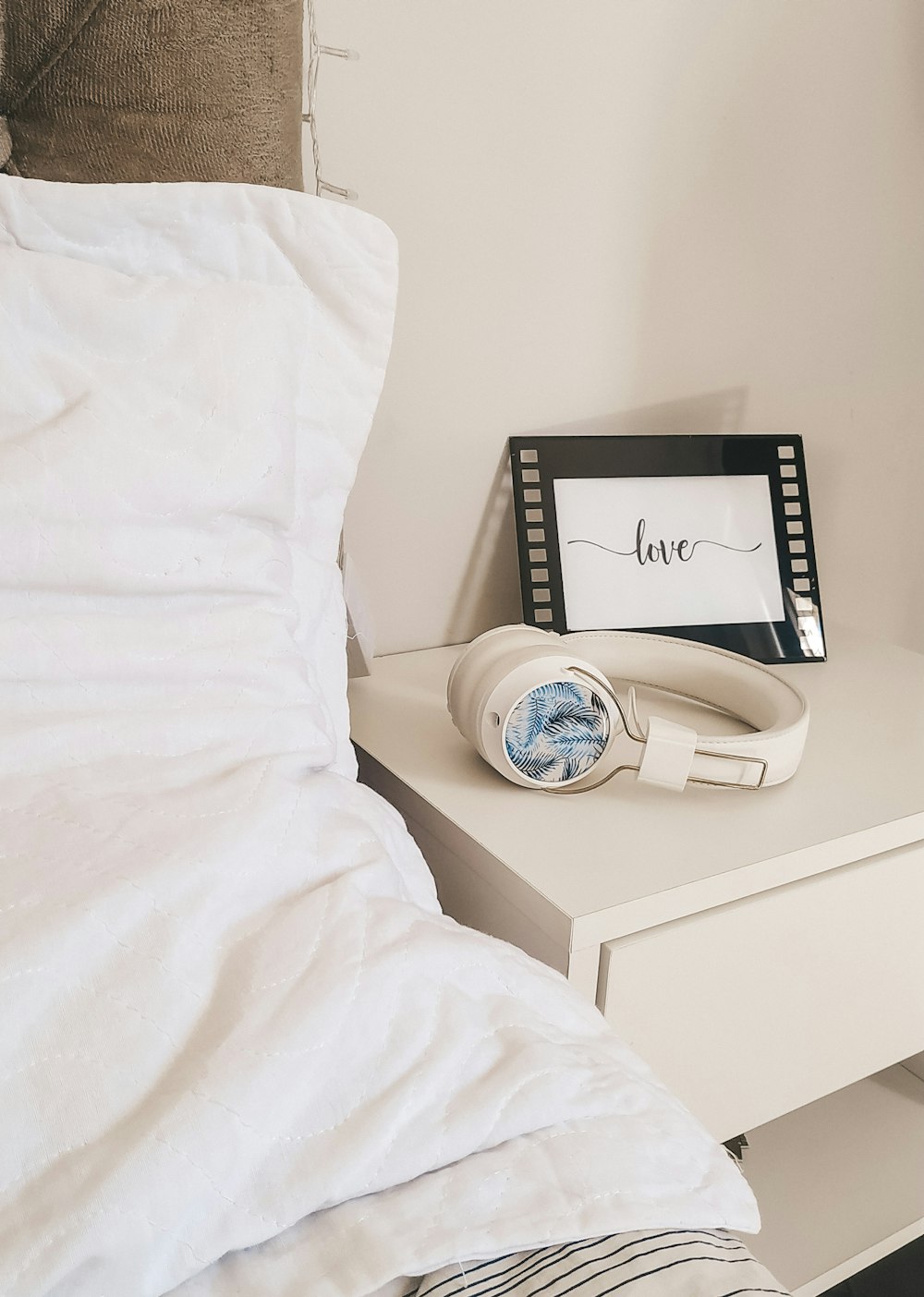 white ceramic mug on white ceramic saucer on white wooden nightstand