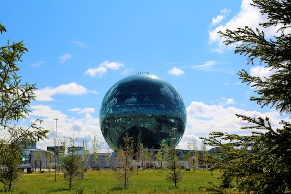 blue and black globe on green grass field under blue sky during daytime