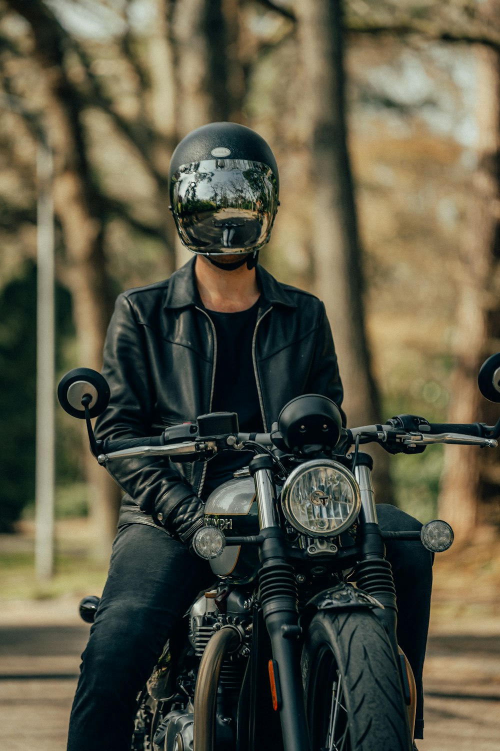 homme en veste en cuir noir conduisant une moto
