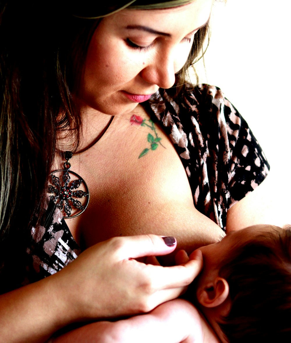 woman in black and white floral shirt with tattoo on her right hand