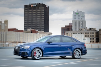 blue sedan parked near brown concrete building during daytime