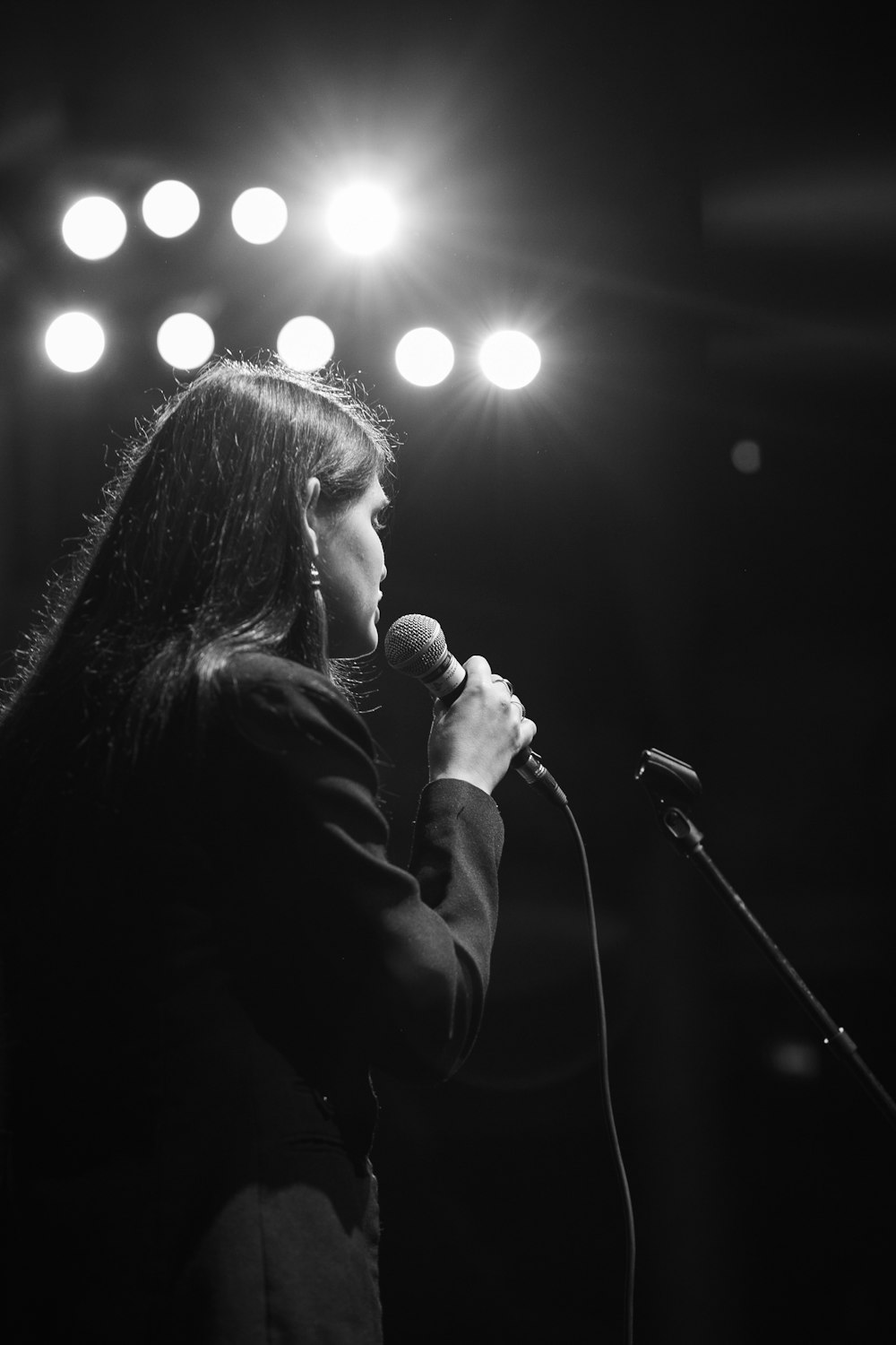 grayscale photo of woman singing