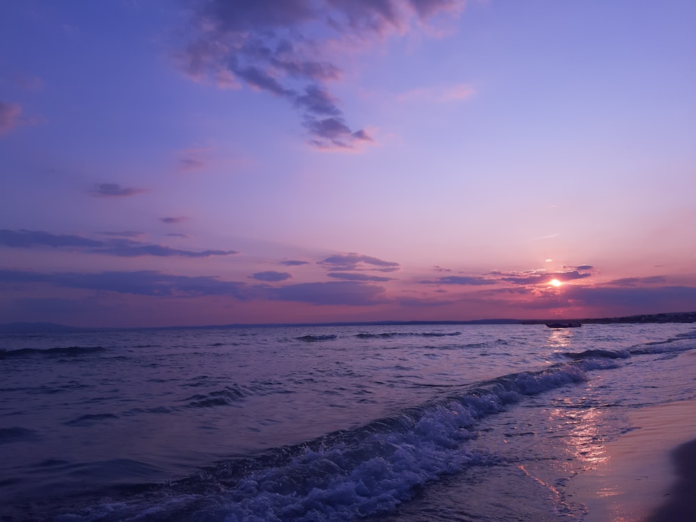 ocean waves crashing on shore during sunset