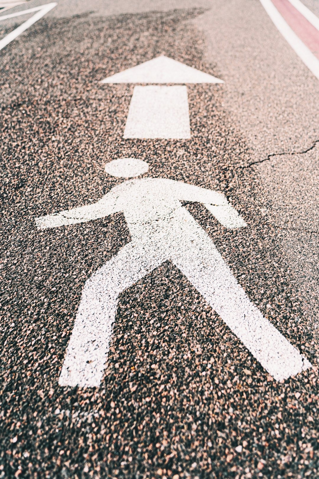 white arrow sign on gray asphalt road