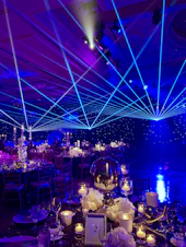 An event setup with elegant lighting and guests engaging in a lively atmosphere.