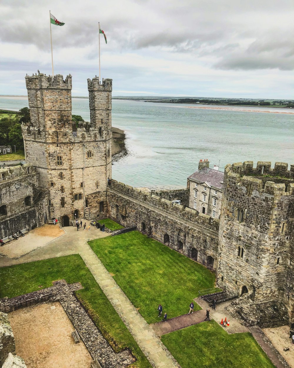 Castillo de hormigón gris cerca del cuerpo de agua durante el día