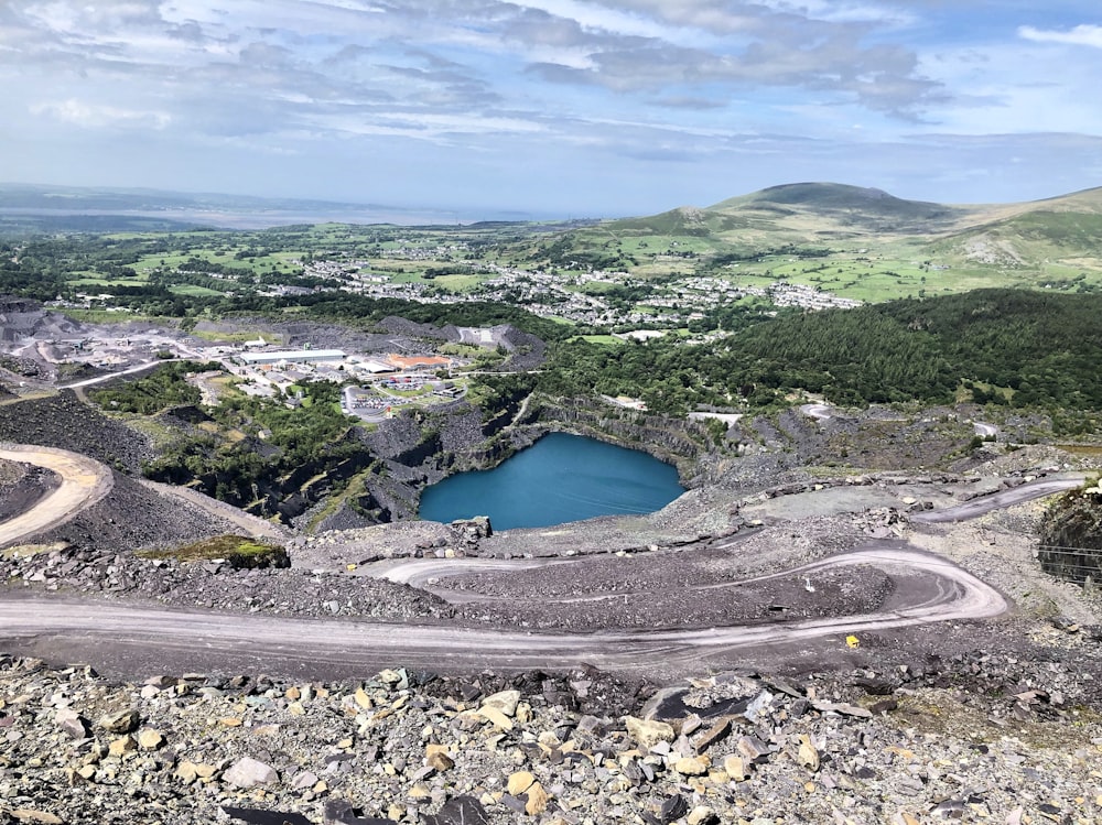 aerial view of lake in the middle of green mountains during daytime