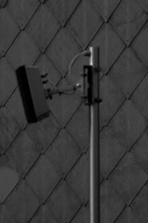 Close-up of a geophone device placed on a tiled floor during leak detection service.