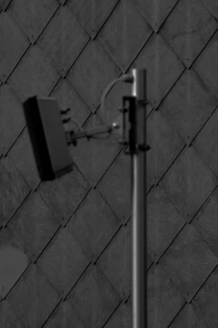 Close-up of a geophone device placed on a tiled floor during leak detection service.