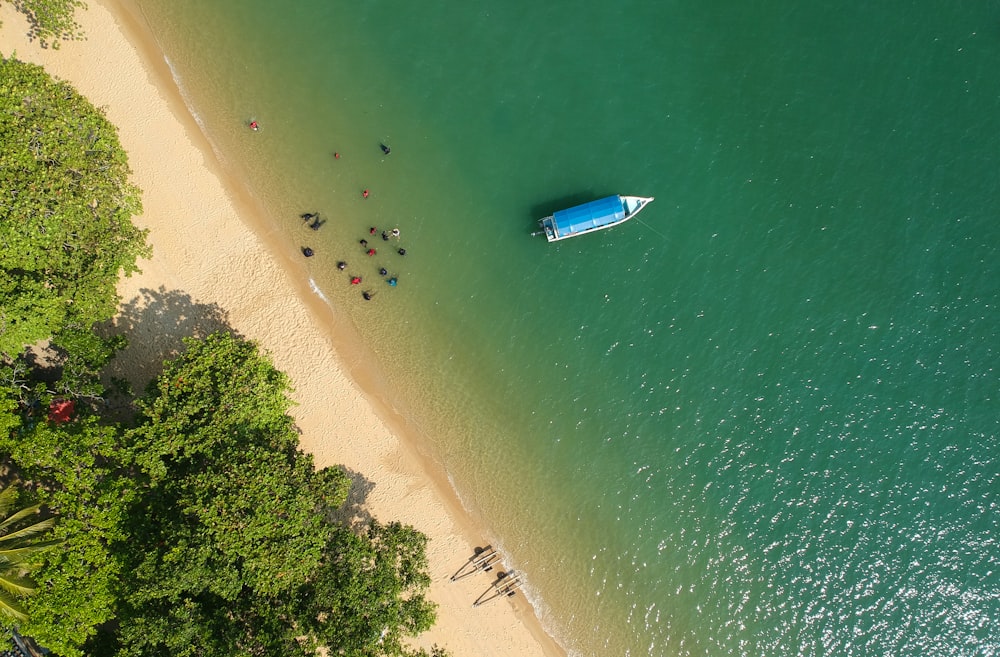 a blue boat floating on top of a body of water