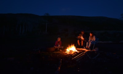 Participants sharing stories around a campfire in an outdoor learning setting.