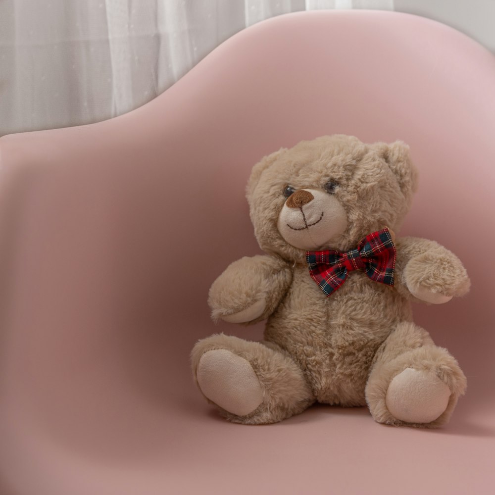 핑크 의자에 갈색 곰 봉제 장난감