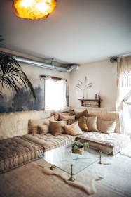 A softly lit living room with beige and blush pink accents and plush cushions.