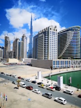 cars parked on parking lot near high rise buildings during daytime