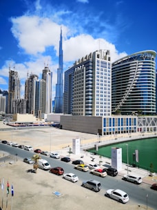 cars parked on parking lot near high rise buildings during daytime