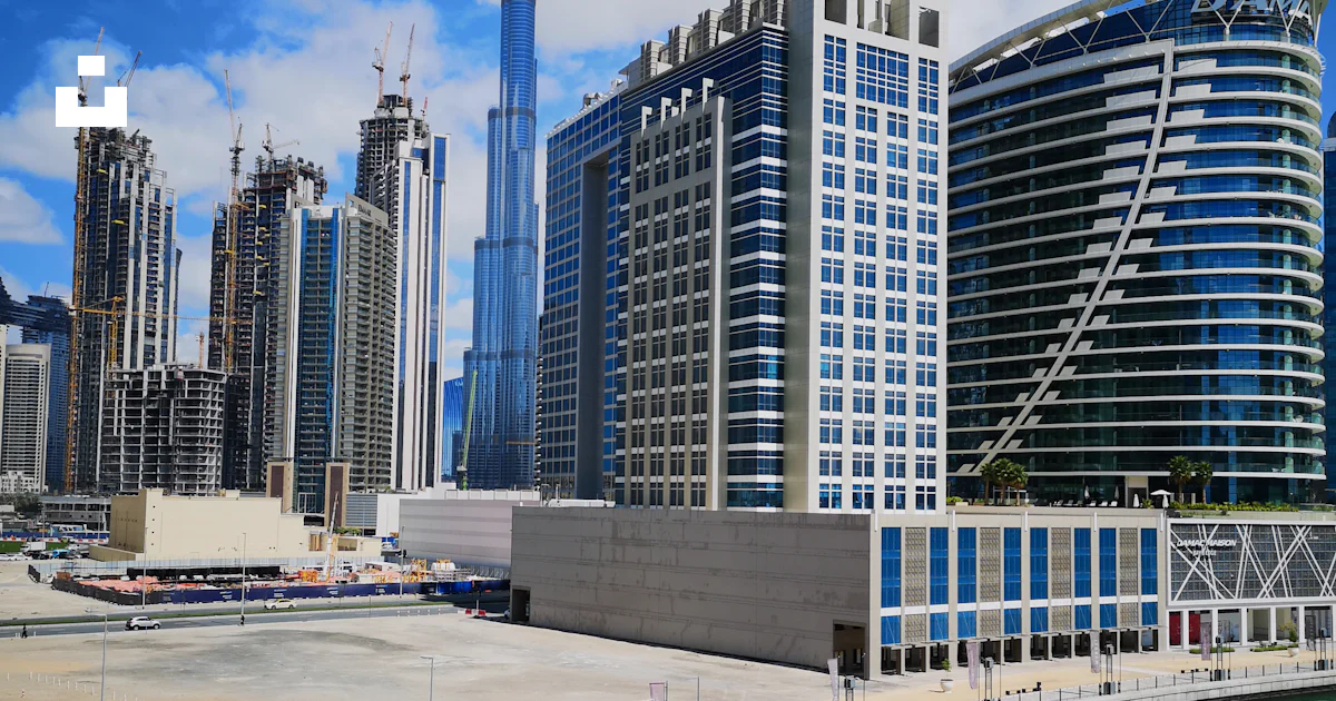 Cars parked on parking lot near high rise buildings during daytime ...