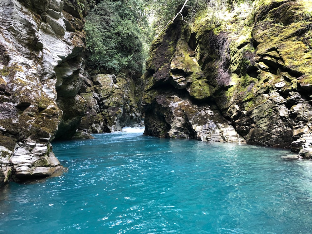 body of water between rocky mountains during daytime